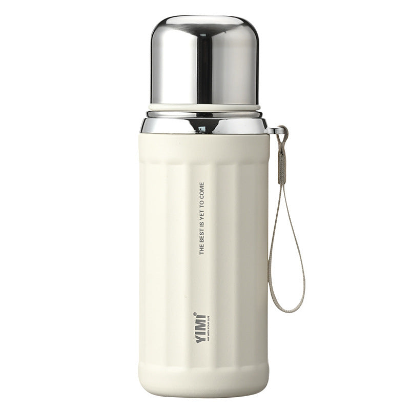 A cream-colored vacuum insulated water bottle with a shiny silver stainless steel lid and a matching carrying strap, shown on a plain white background.
