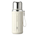 A cream-colored vacuum insulated water bottle with a shiny silver stainless steel lid and a matching carrying strap, shown on a plain white background.