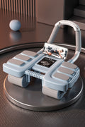 A light blue and gray fitness device with a handlebar, foot pedals, and a built-in smartphone holder, displayed on a circular platform in a modern indoor setting.